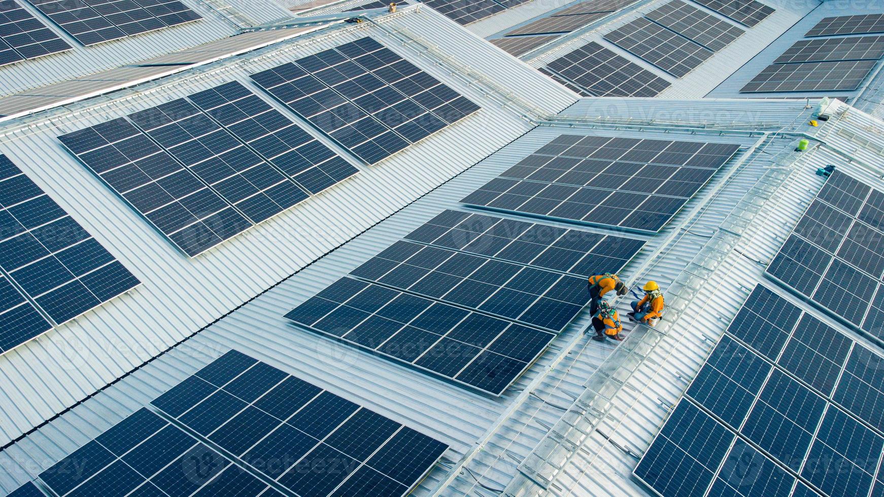 Fly over unidentified Engineering set up a Solar cell on the roof of a large industrial factory. Solar roofs are generating renewable energy for the industry. photo