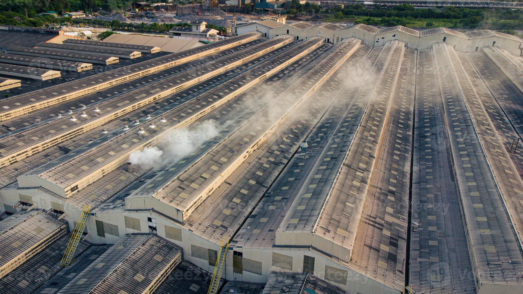 Los humos tóxicos se propagan desde el techo de una planta industrial. Las plantas industriales emiten grandes cantidades de humo de las fábricas durante la producción. que crea la contaminación del aire para el mundo. foto