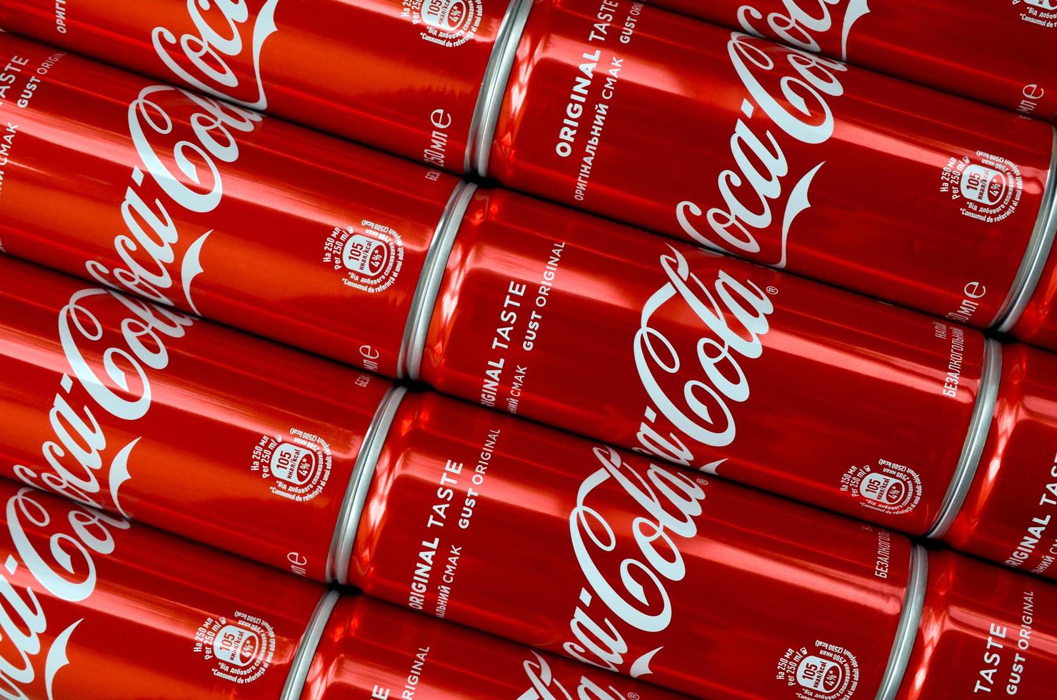 KHARKOV. UKRAINE - MAY 2, 2022 Coca-Cola logo printed on aluminium tin cans close up in shopping mall photo