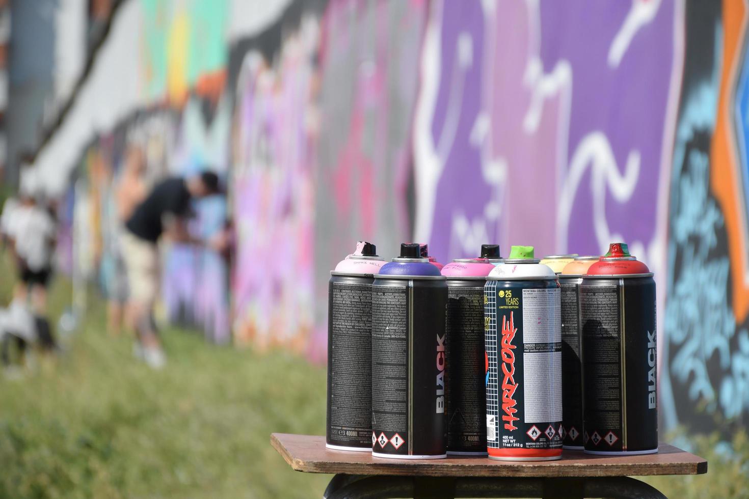 KHARKOV. UKRAINE - MAY 2, 2022 Used Montana black and hardcore aerosol spray cans against graffiti paintings. MTN or Montana-cans is manufacturer of high pressure spray paint goods photo