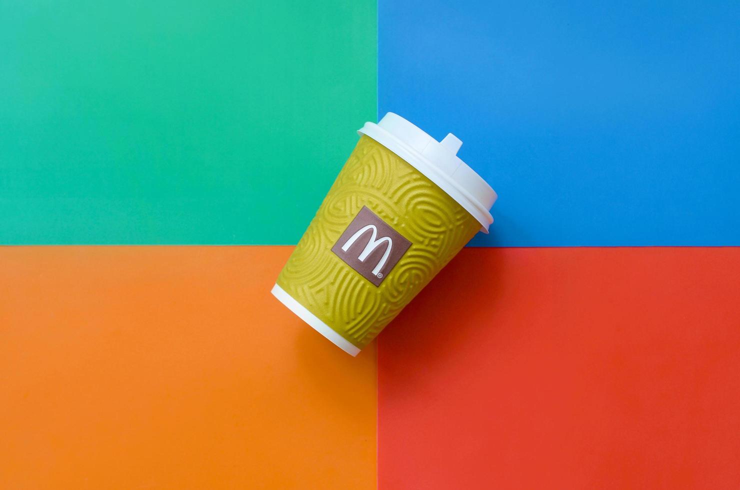 KHARKOV, UKRAINE - MAY 12, 2022 McDonald's paper disposable coffee cup on bright colors mix background photo