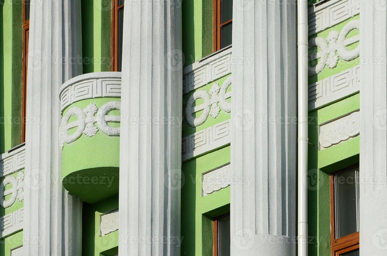 antiguo edificio restaurado de varias plantas con columnas antiguas, pintado de verde foto