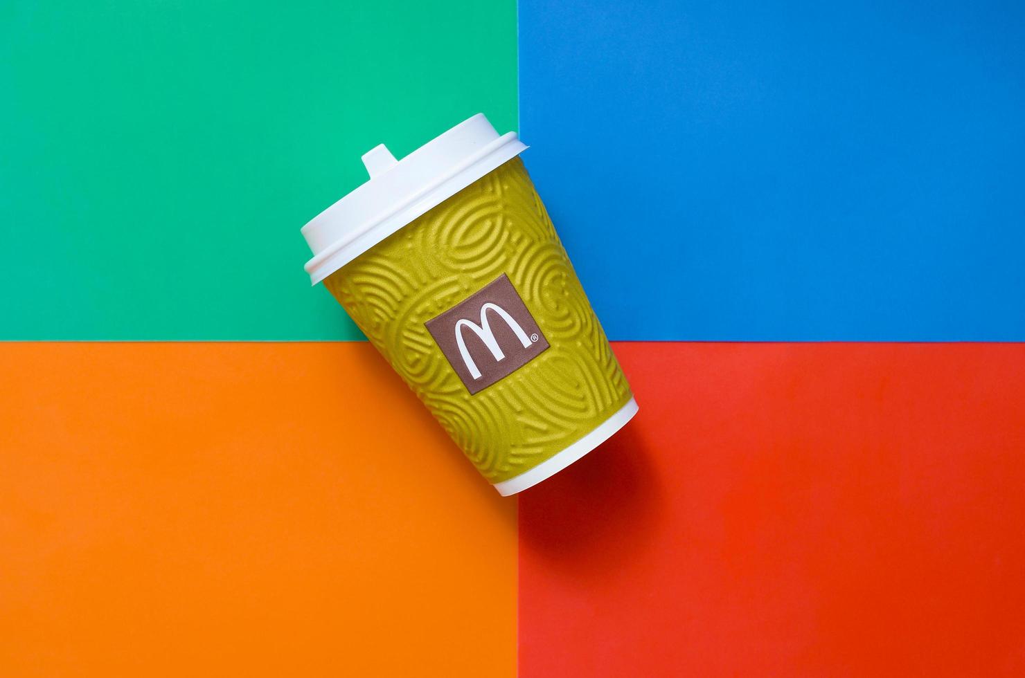 KHARKOV, UKRAINE - MAY 12, 2022 McDonald's paper disposable coffee cup on bright colors mix background photo