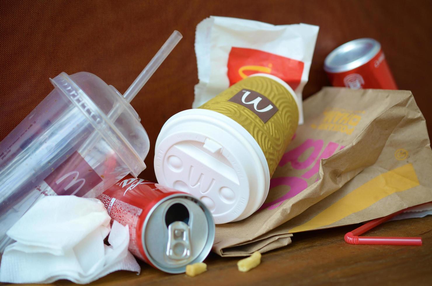 KHARKOV, UKRAINE - MAY 12, 2022 McDonald's garbage or disposable trash on dark brown wooden background photo