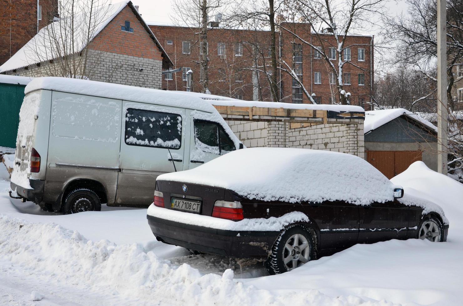 KHARKOV, UKRAINE - JANUARY 4, 2022 A parked car under a thick layer of snow. Consequences of a strong and unexpected snowfall in Ukraine photo