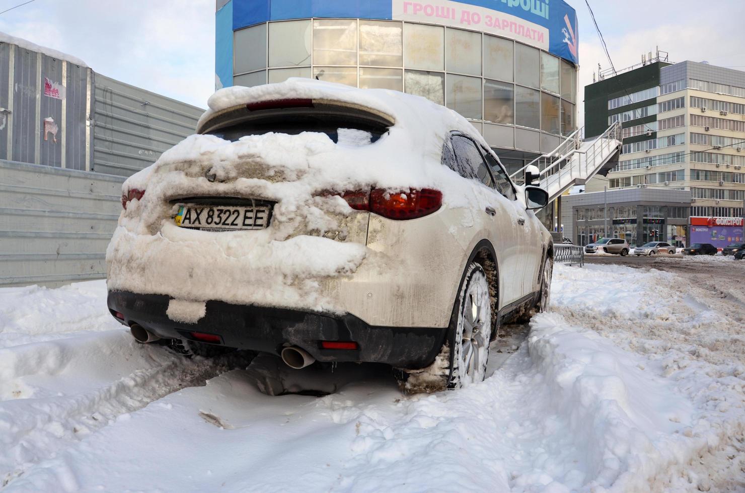 KHARKOV, UKRAINE - JANUARY 4, 2022 A parked car under a thick layer of snow. Consequences of a strong and unexpected snowfall in Ukraine photo