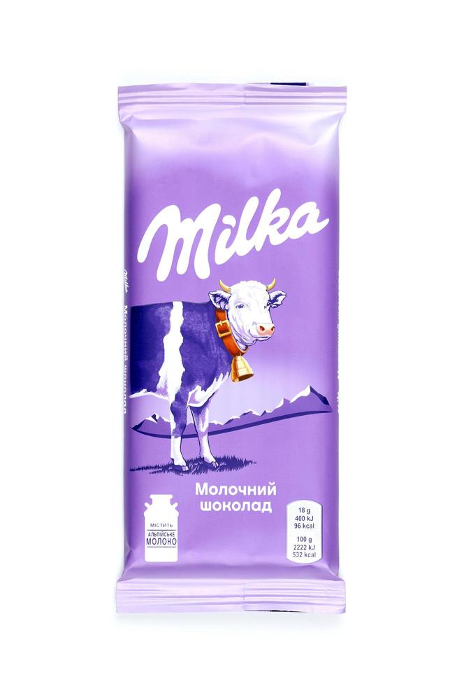 KHARKOV. UKRAINE - MAY 2, 2022 Milka chocolate product with classical lilac color wrapping design on white table photo