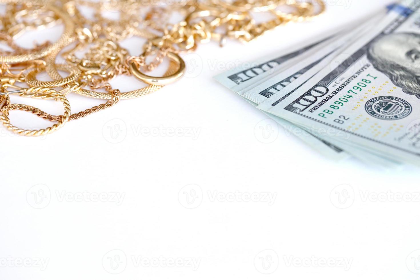 Many expensive golden jewerly rings, earrings and necklaces with big amount of US dollar bills on white background. Pawnshop or jewerly shop photo