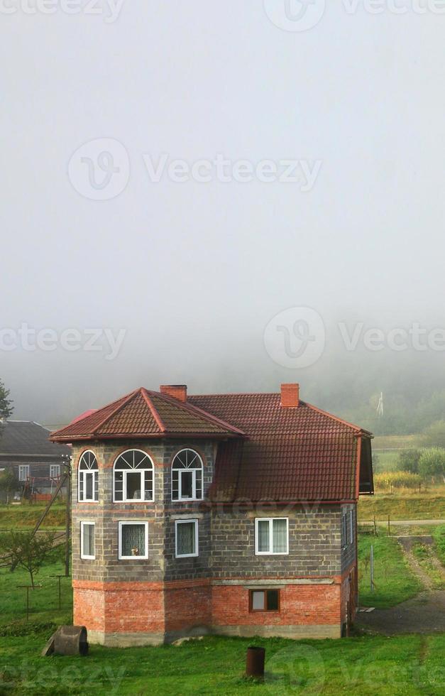 The apartment building is in front of a thick layer of fog. Living in a mountainous area in the Carpathians, Ukraine photo