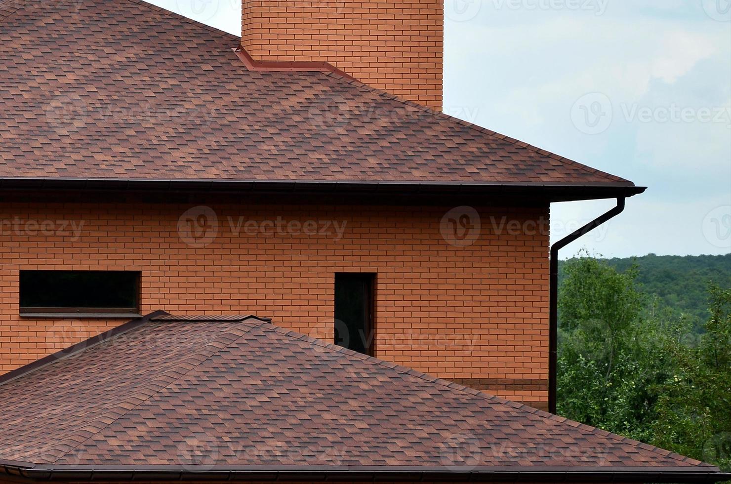 The house is equipped with high-quality roofing of shingles bitumen tiles. A good example of perfect roofing. The roof is reliably protected from adverse weather conditions photo