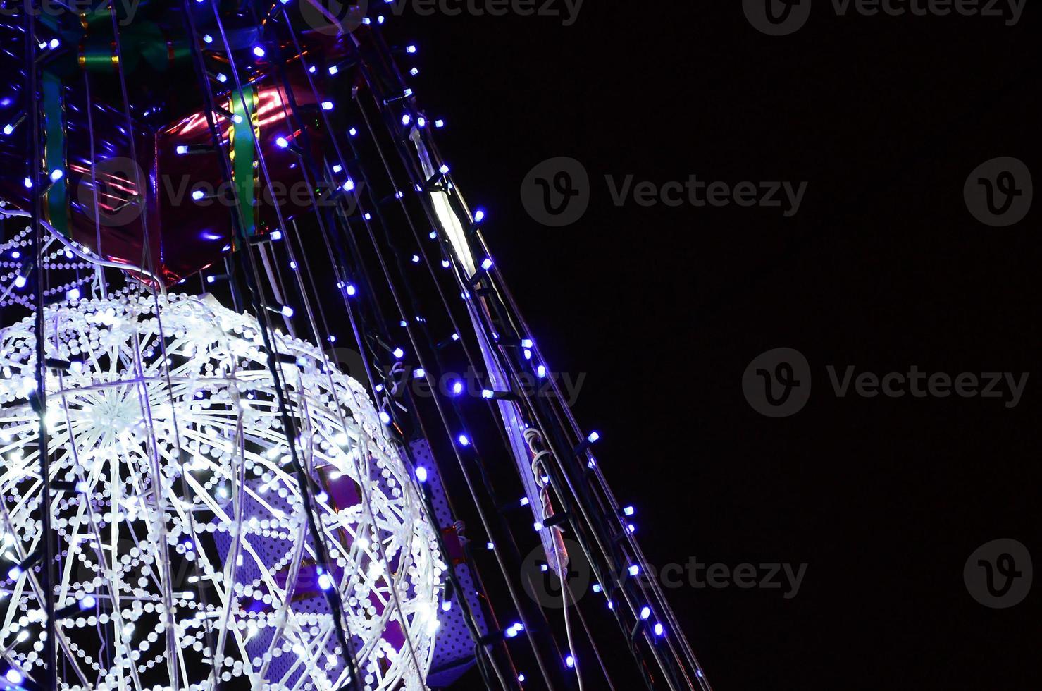 Fragment of the New Year tree. A lot of round lights of blue color are located on a conical frame photo