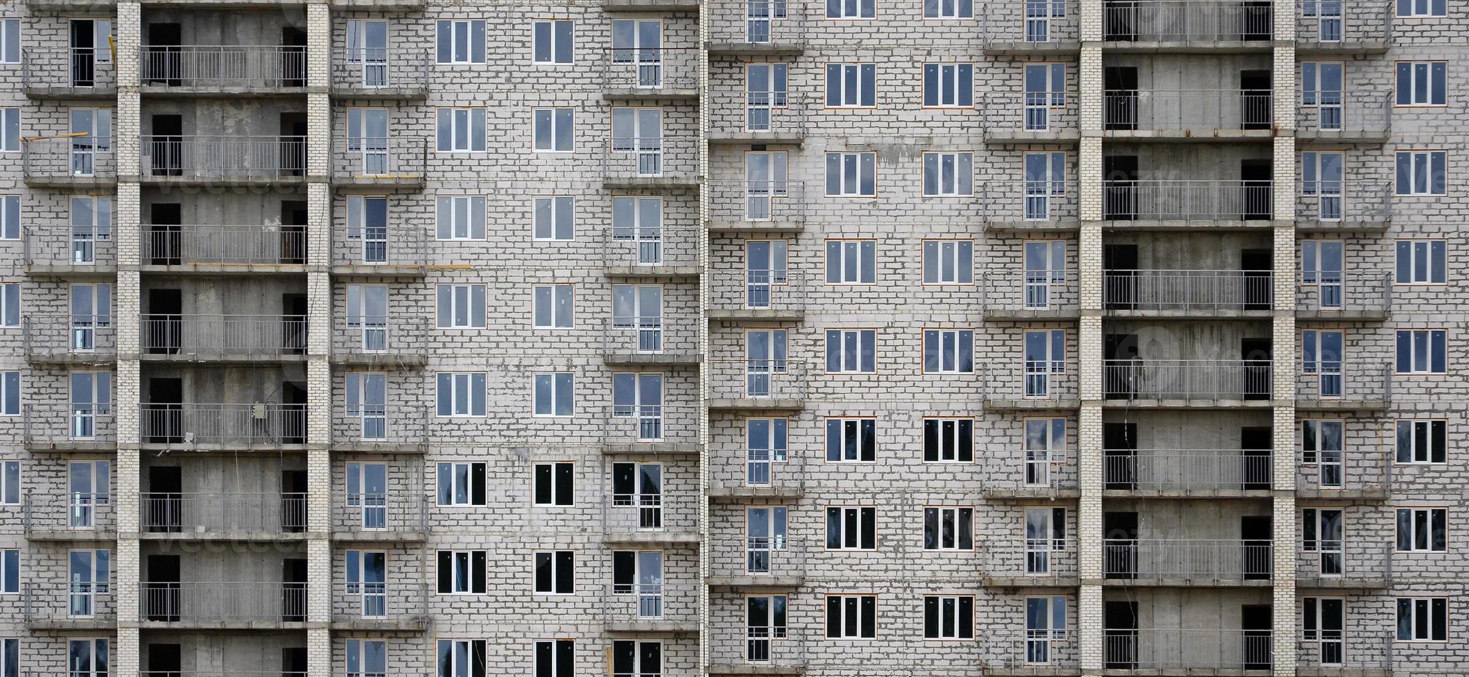 Textured pattern of a russian whitestone residential house building wall with many windows and balcony under construction photo