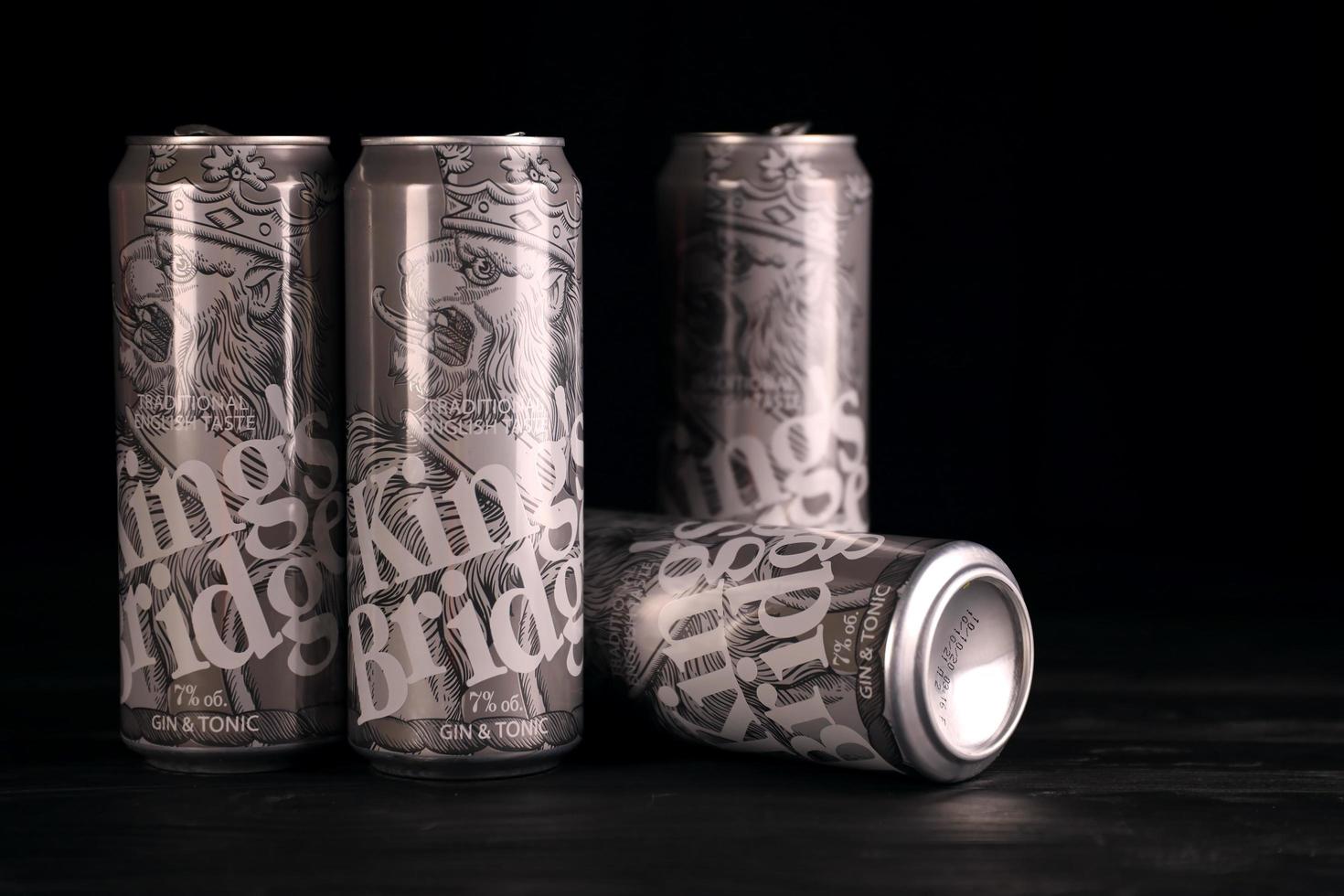 KHARKOV. UKRAINE - MAY 2, 2022 Kings Bridge beer cans on black wooden table. KingsBridge is beer manufactured by Ukrainian company Napoi Plus photo