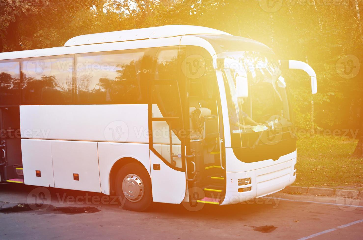 autobús turístico blanco para excursiones. el autobús está estacionado en un estacionamiento cerca del parque foto