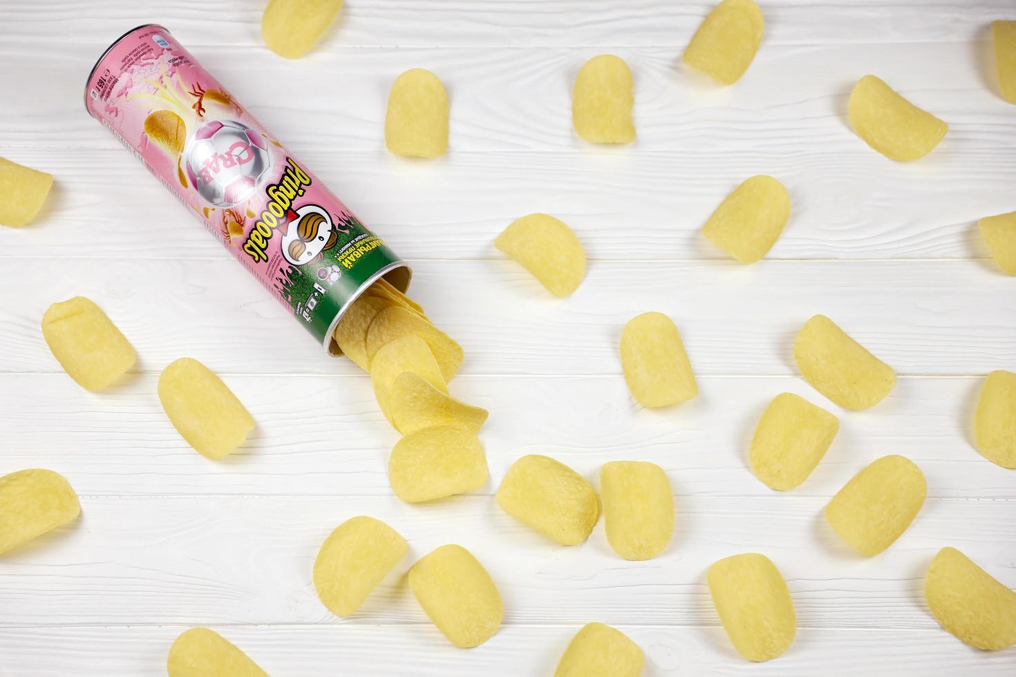 KHARKOV, UKRAINE - MAY 5, 2022 Pringles crab flavour. Cardboard tube can with Pringles potato chips on white table. Pringles is a brand of potato snack chips owned by Kellogg Company photo