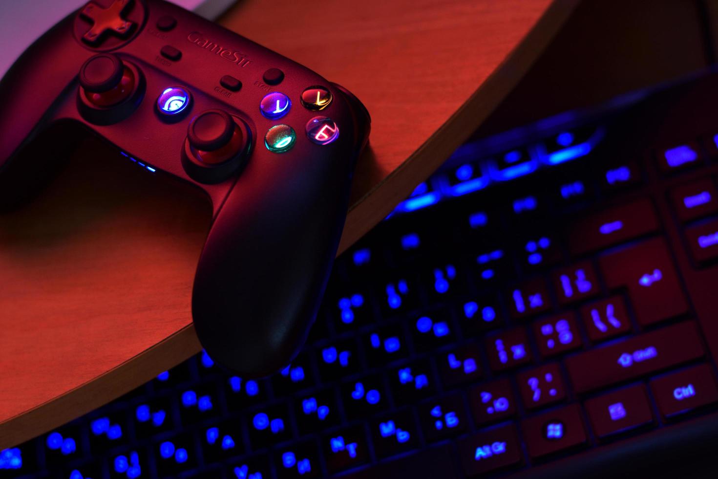 KHARKOV, UKRAINE - MAY 12, 2022 Gamesir g3s video game controller and a4tech keyboard on office table photo