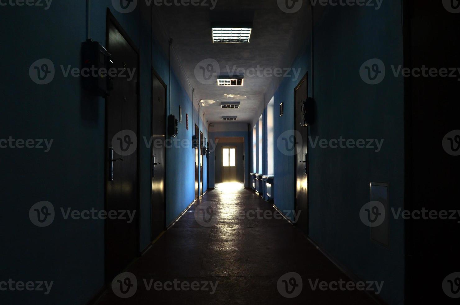 The gloomy corridor of a neglected public building. Public space in a poor residential high-rise building photo