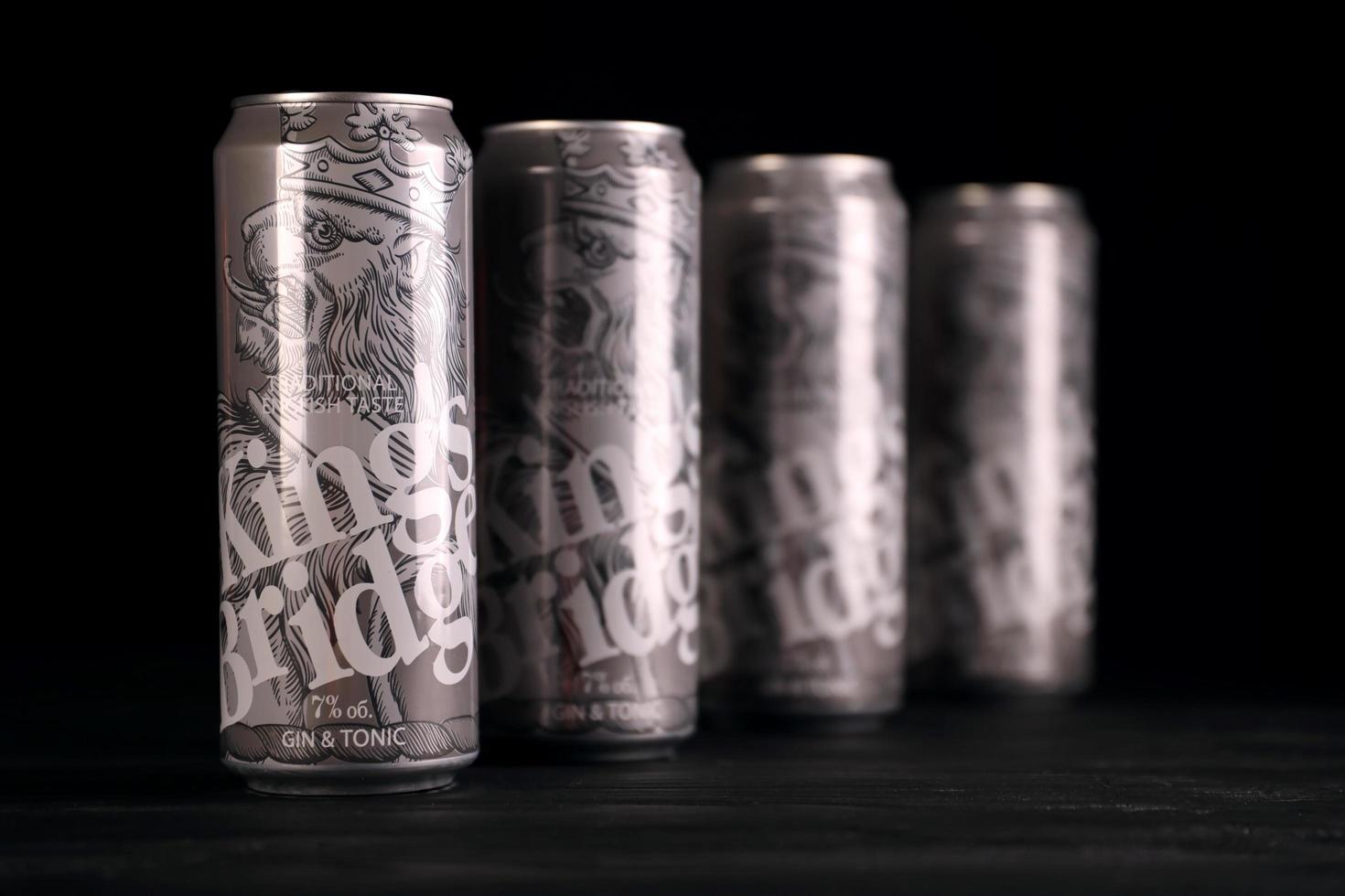KHARKOV, UKRAINE - MAY 12, 2022 Kings Bridge beer cans on black wooden table. KingsBridge is beer manufactured by Ukrainian company Napoi Plus photo