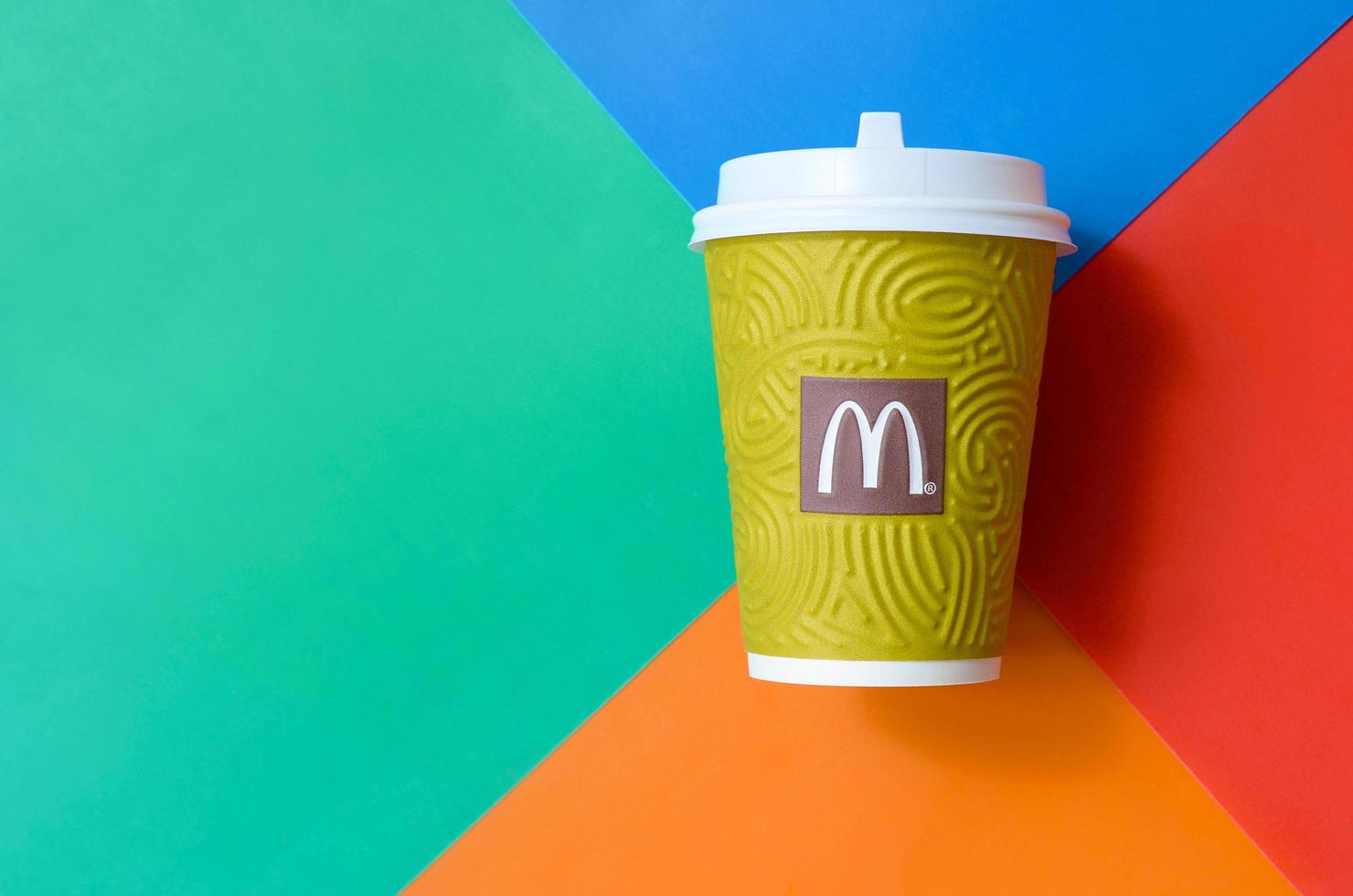 KHARKOV, UKRAINE - MAY 12, 2022 McDonald's paper disposable coffee cup on bright colors mix background photo