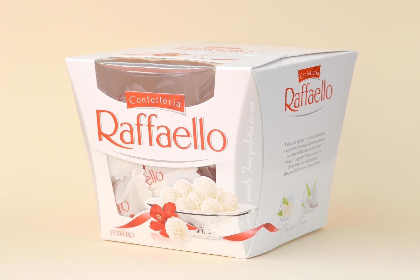 KHARKOV. UKRAINE - MAY 2, 2022 Raffaello candies on beige background. Raffaello is a spherical coconut almond confection that Italian manufacturer Ferrero brought to the market in 1990 photo