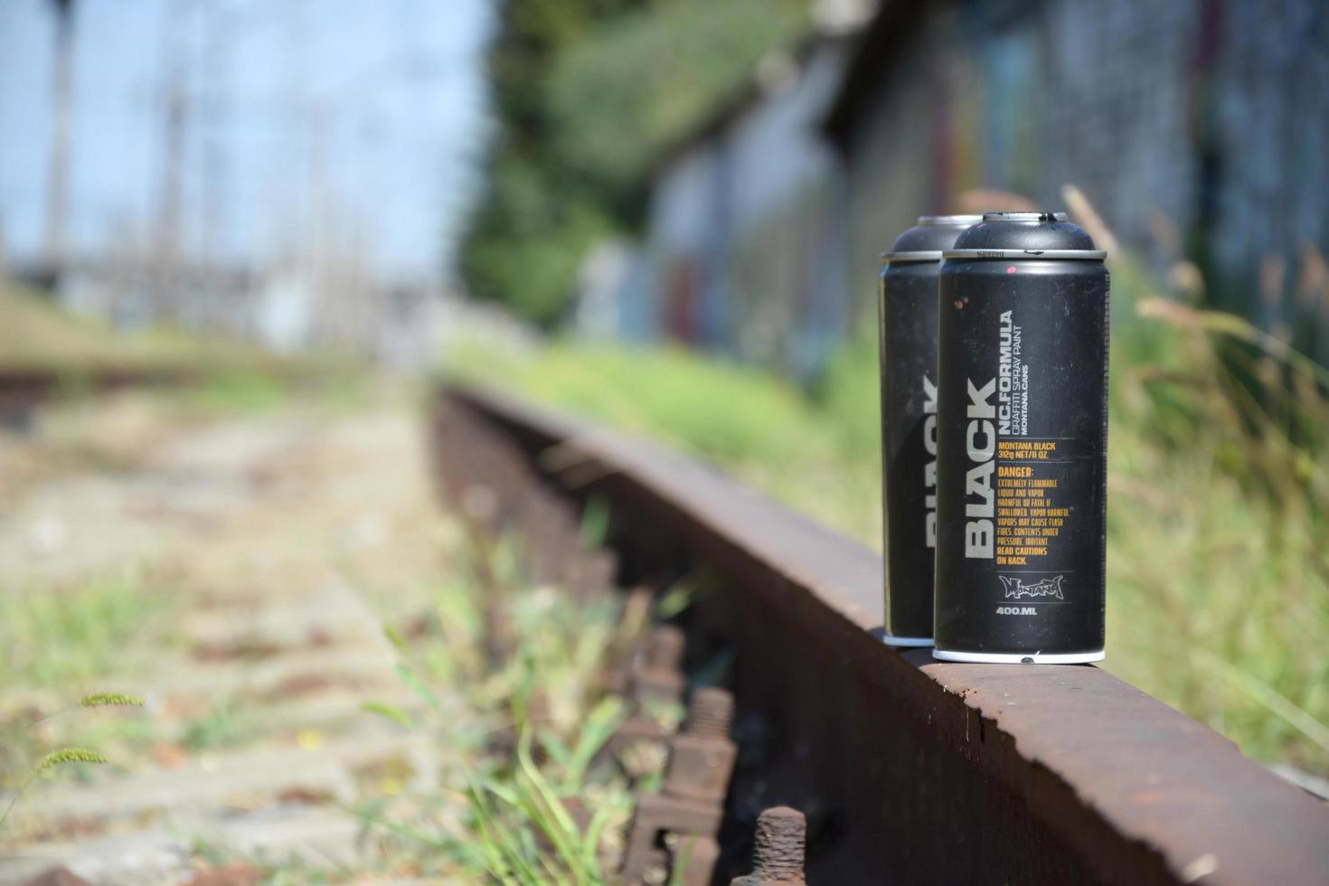 KHARKOV. UKRAINE - MAY 2, 2022 Used Montana black aerosol spray cans against graffiti paintings. MTN or Montana-cans is manufacturer of high pressure spray paint goods photo