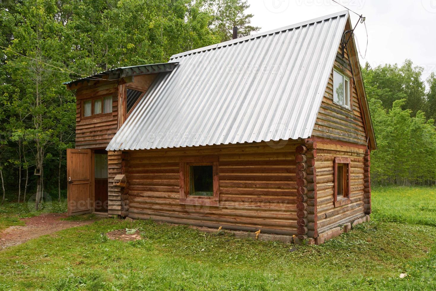 log house in green forest in summer photo