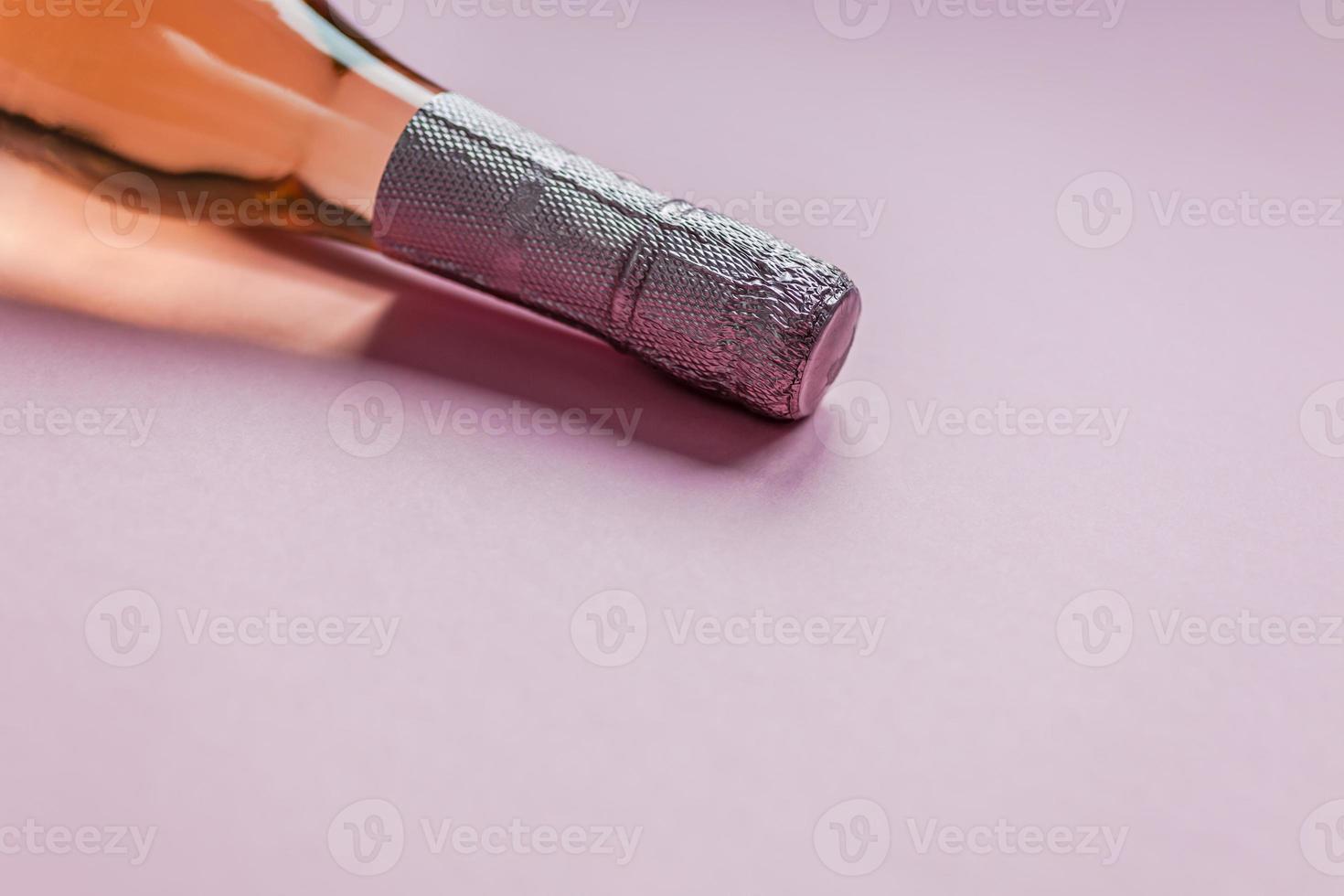 Bottle of rose champagne wine on pink background photo