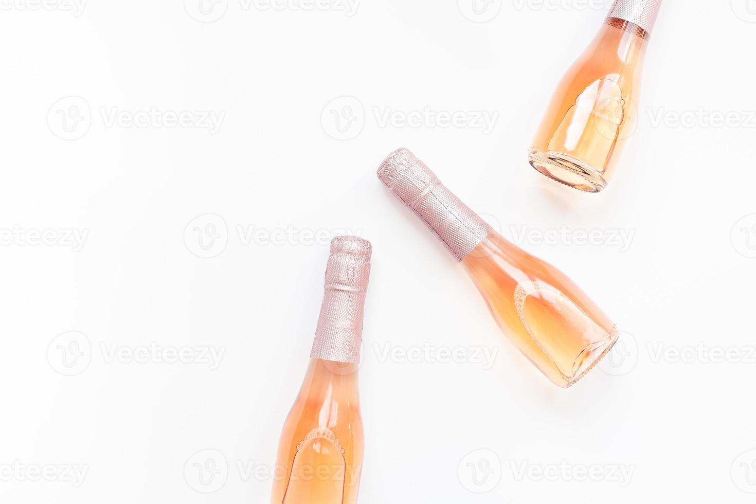 Bottles of rose champagne wine on white background photo