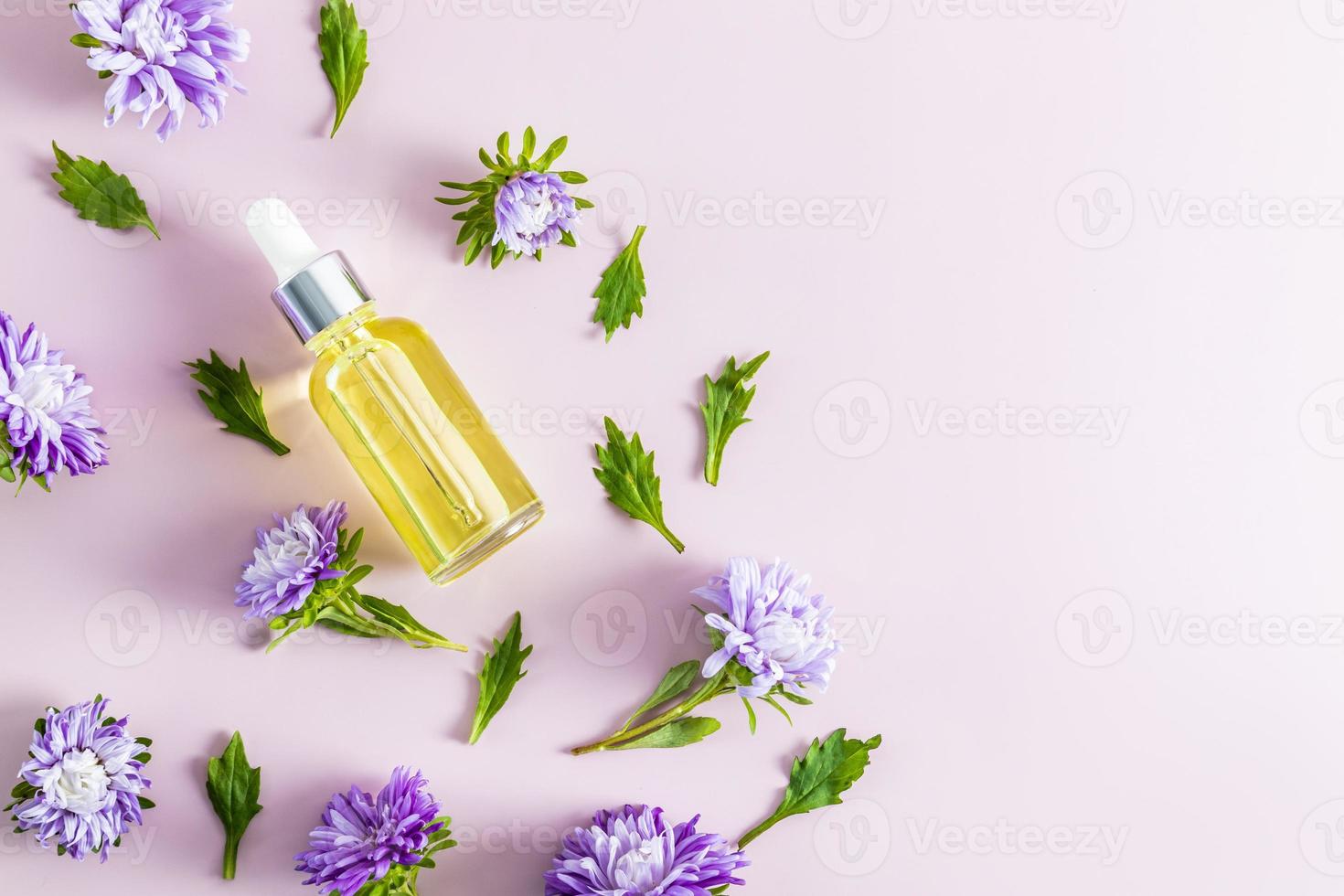 una botella con cuentagotas sobre un fondo pastel con flores de otoño. cosmética activa única. preservación de la piel joven. vista superior. un espacio de copia. foto