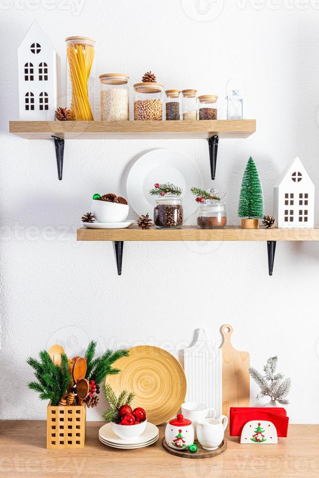 wooden kitchen shelves and part of the countertop with cans for bulk products, various cutting boards and Christmas decorations. photo
