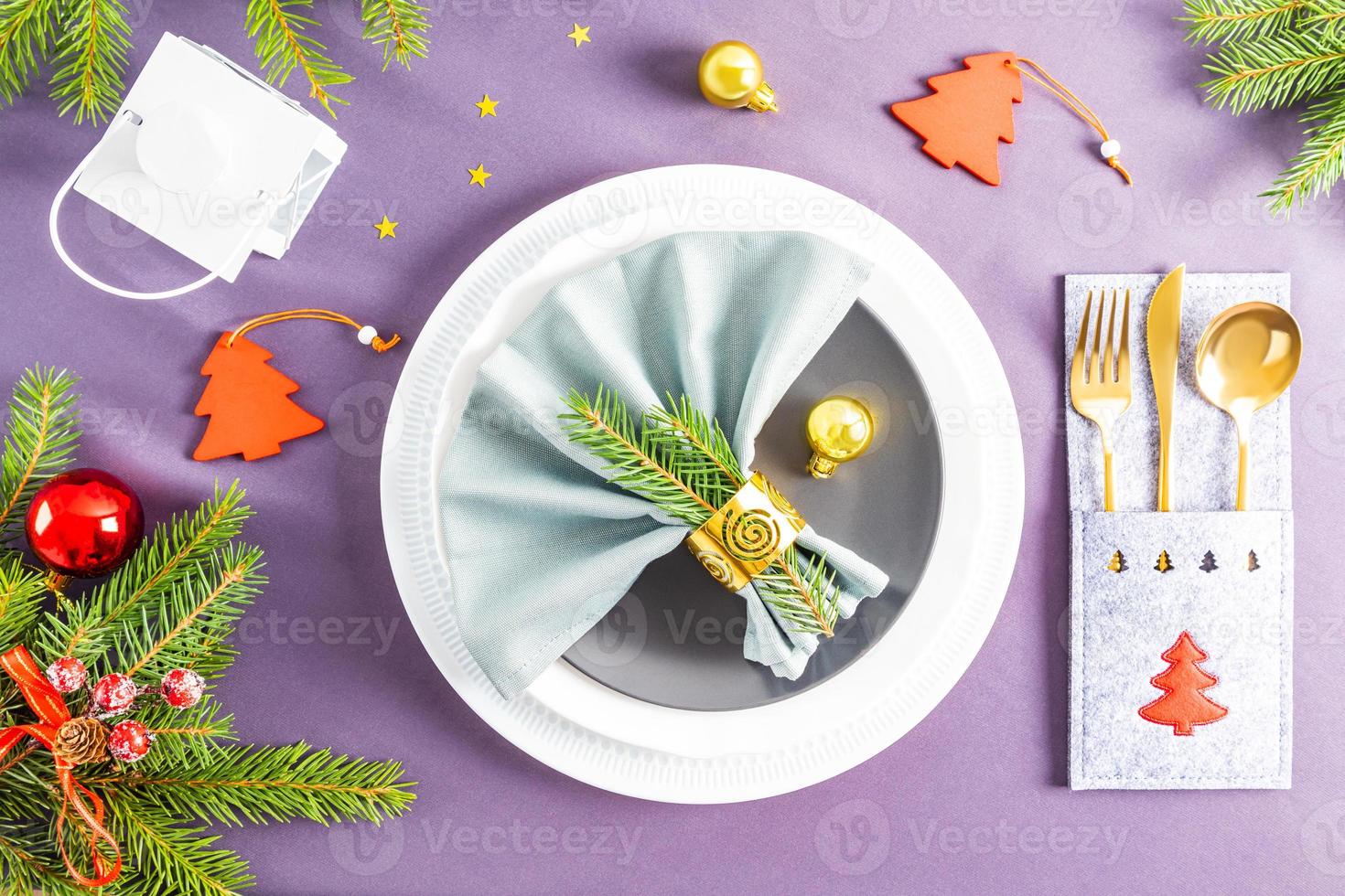 beautiful top view of the festive New Year's serving on the gray background of the tablecloth. fan folded napkin on plates. Christmas decorations. photo
