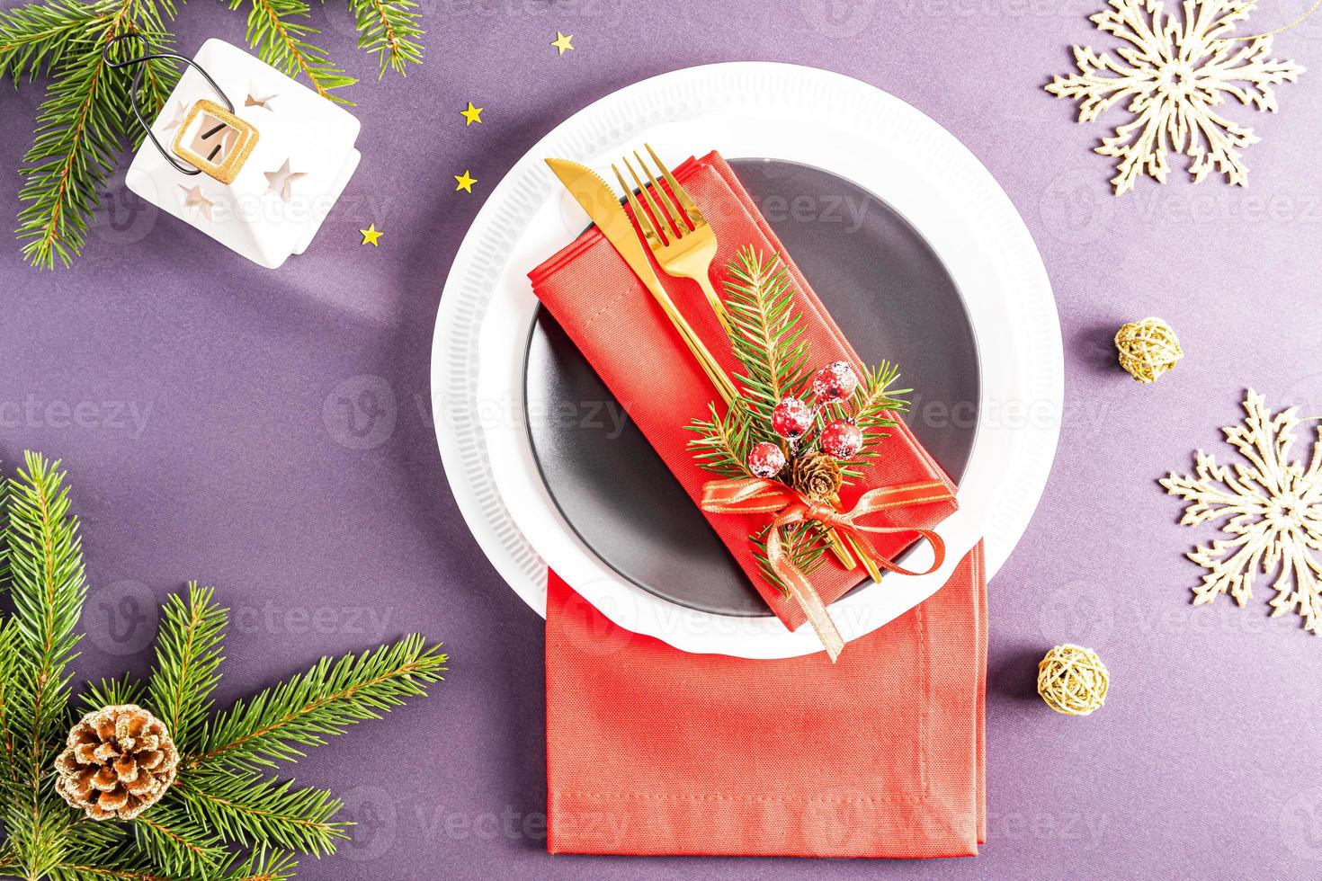 hermoso diseño moderno de la porción navideña de la mesa festiva. servilletas rojas dobladas en abanico con decoraciones en platos blancos y oscuros. foto