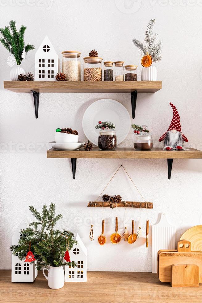 Front view of open wooden kitchen shelves and countertops with various utensils and eco decorations for the New Year. a kitchen in eco style. photo
