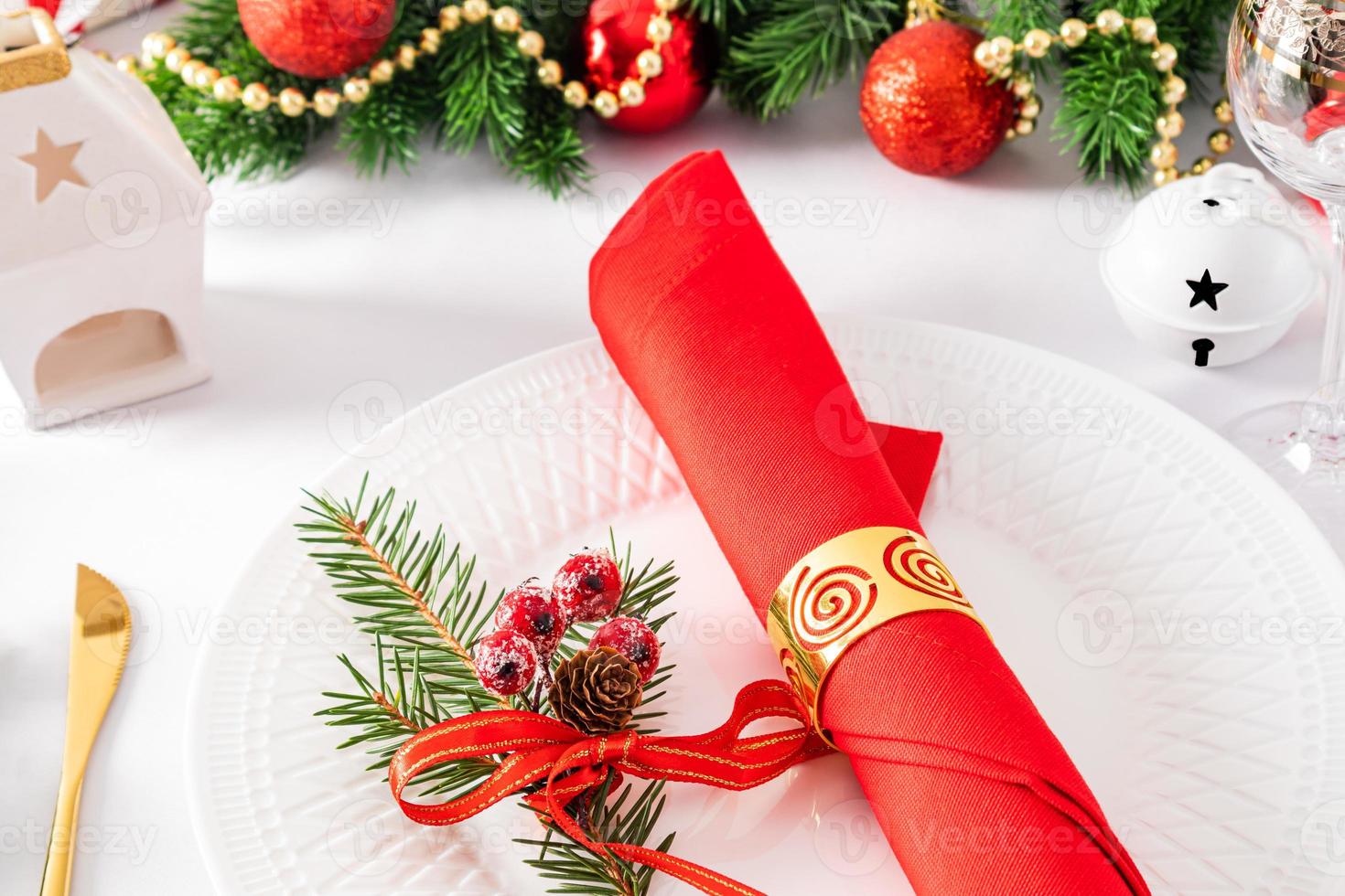 beautiful New Year's table setting. elegant napkins with decorations on a white reflected plate. twigs of spruce. photo