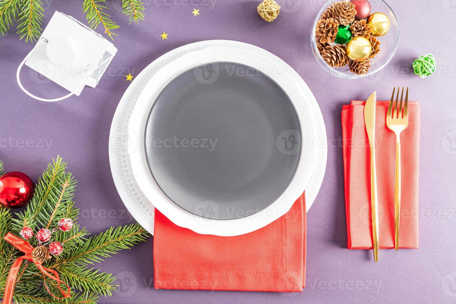 sirviendo la mesa de año nuevo. platos vacíos y cubiertos de oro con adornos. imagen conceptual para menú y afiche. un plato vacío festivo. foto