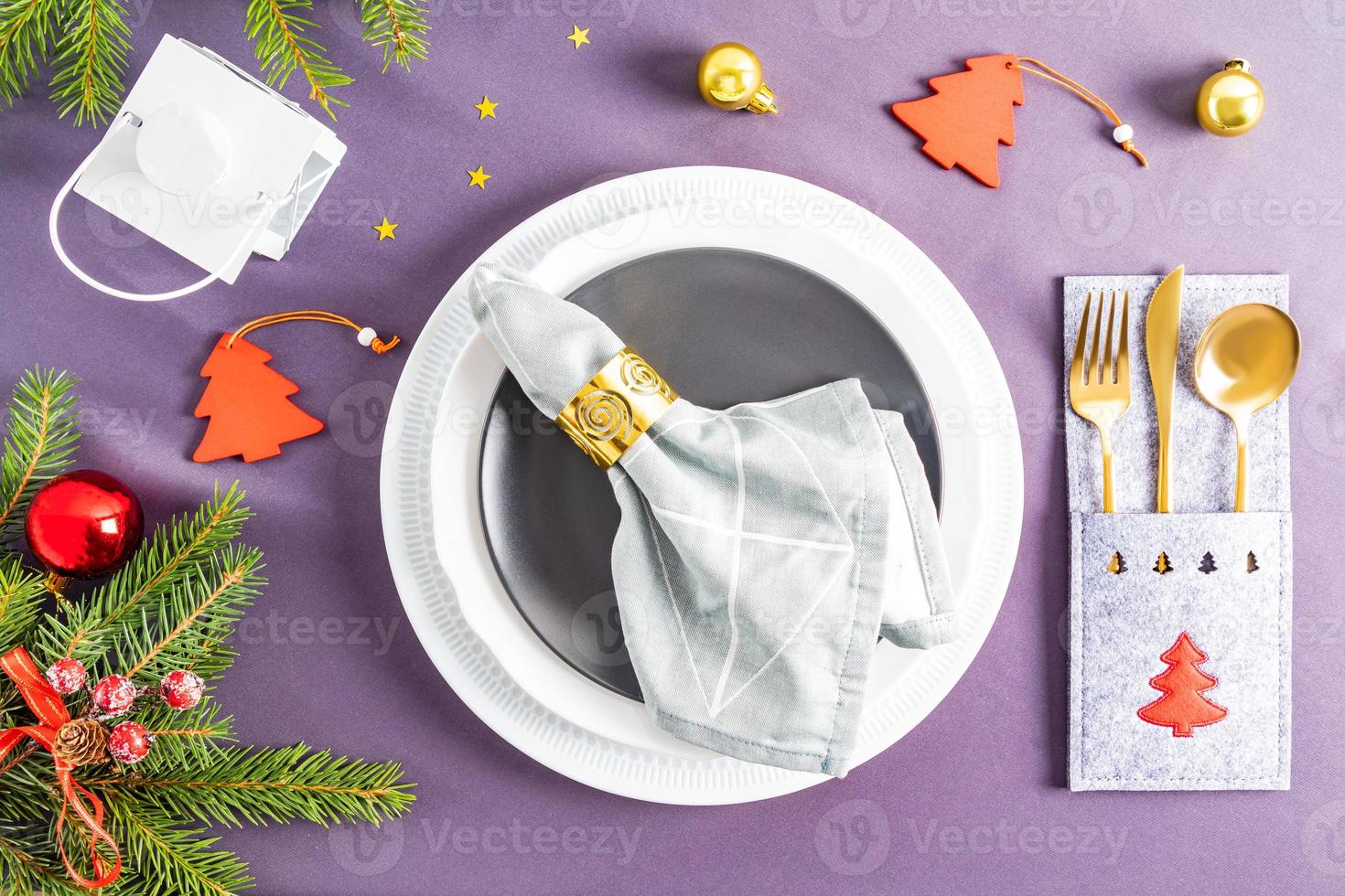 beautiful view of the festive serving of the New Year's or Christmas table. a set of white and dark plates and gold cutlery with decorations. photo