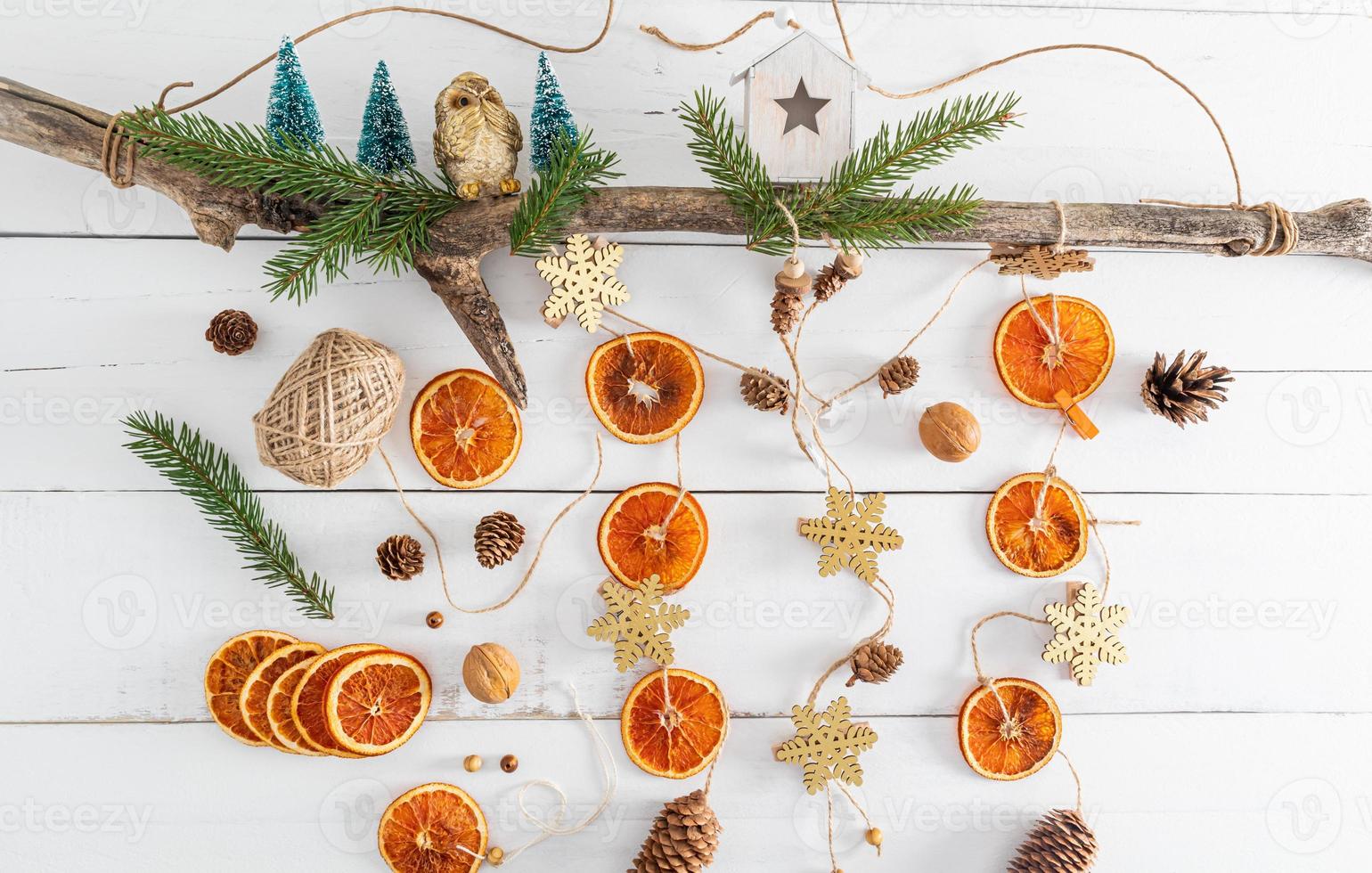 New Year's garland handmade from natural organic dried oranges, cones on a wooden tree trunk. top view. photo