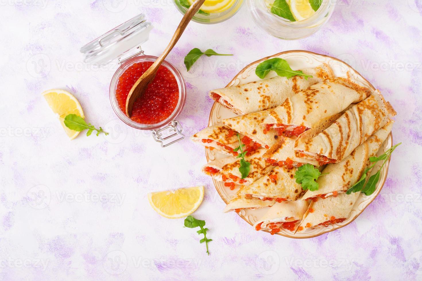 Pancakes with red caviar and cream cheese. Top view photo