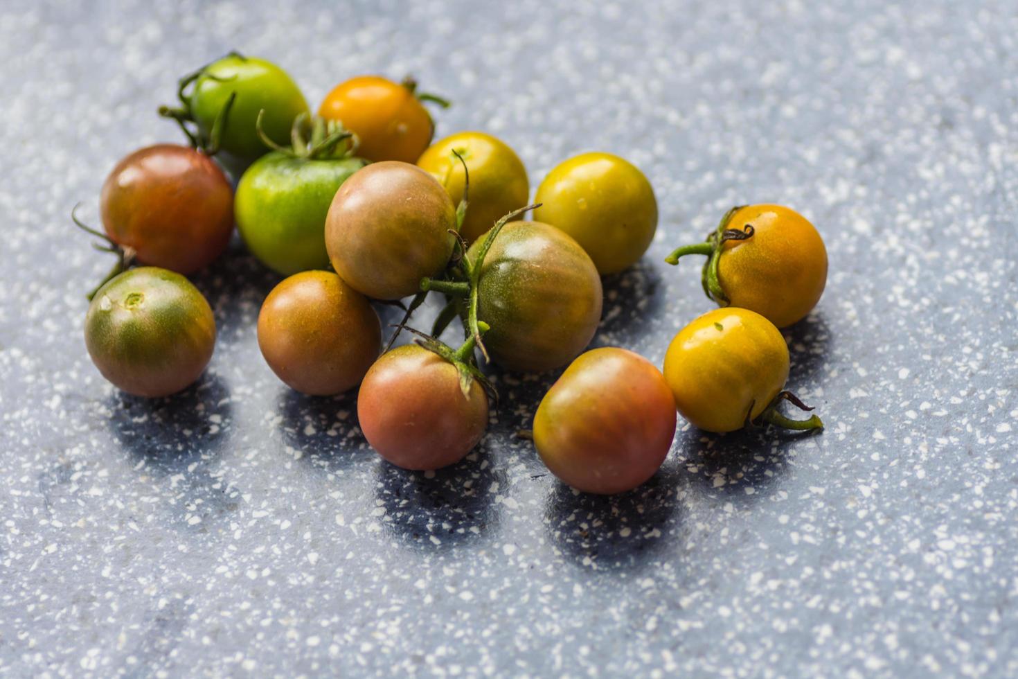 muchos pequeños tomates verdes con diferentes colores foto