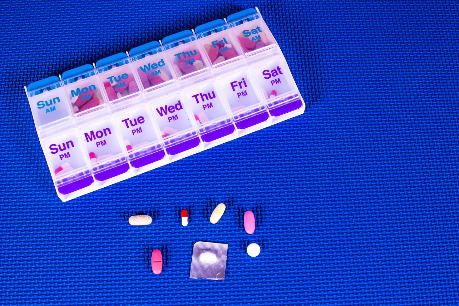 Pill Box Container On Blue Pattern Background photo