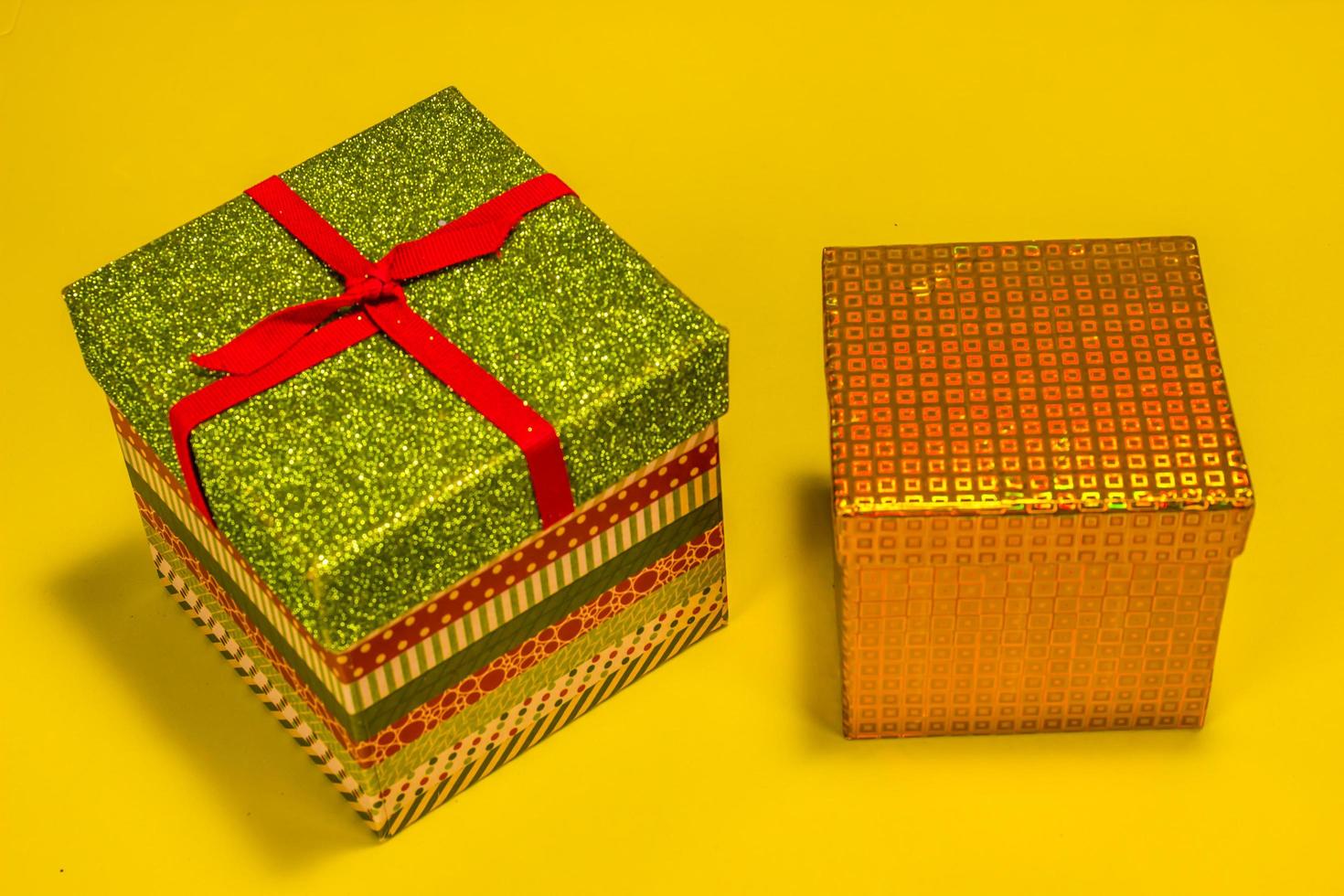 Two Decorative Christmas Gift Boxes On Yellow Background photo