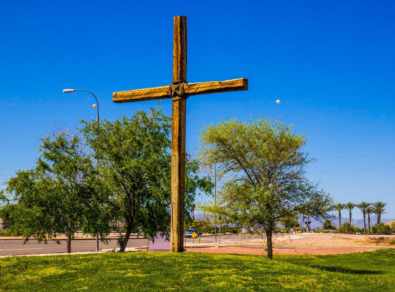 cruz religiosa en loma cubierta de hierba foto