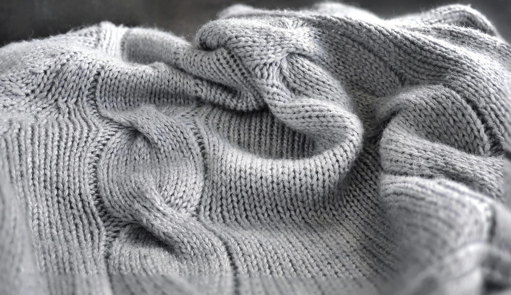 Selective focus Knitted Woolen, Knitwear Fabric Texture, Warm Clothes for Fall and Winter, Woven, Woolen, Sweaters, gray color with Dark Background and copy space photo