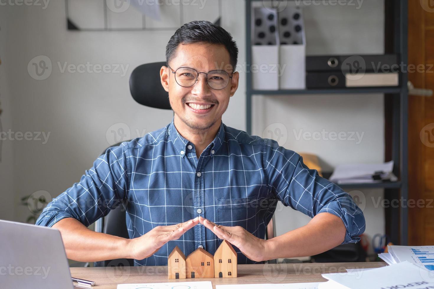 Accountant, businessman, real estate agent, businessman handing model house to customers along with house interest calculation documents for customers to sign. photo