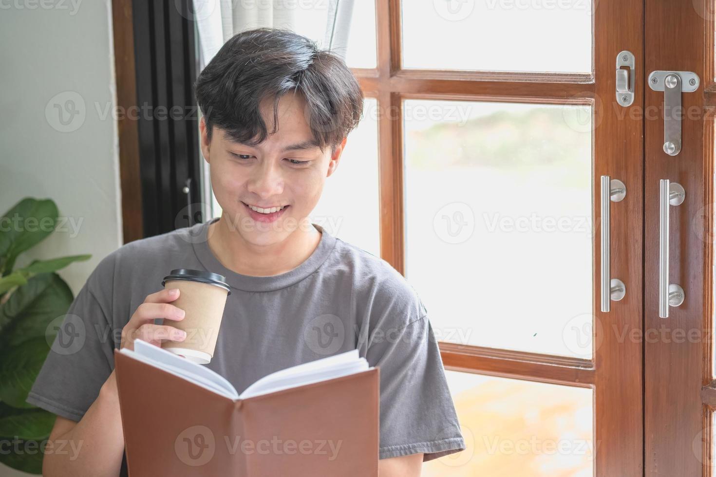 Portrait of a white man sitting inside the house reading and drinking coffee to relax on vacation. photo
