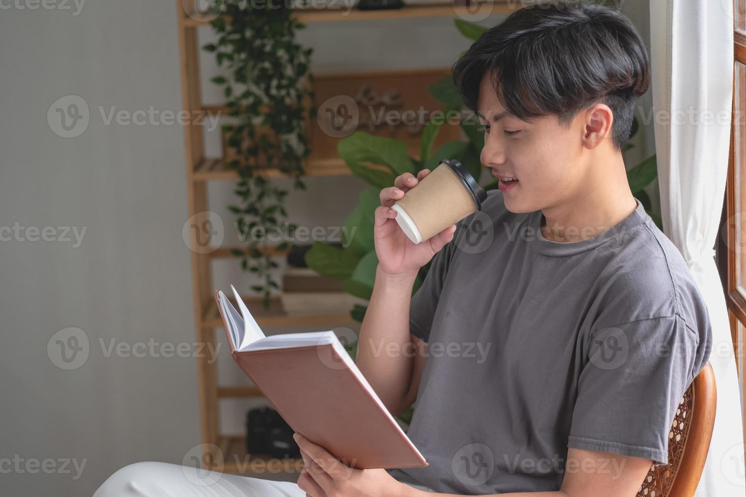 Portrait of a white man sitting inside the house reading and drinking coffee to relax on vacation. photo