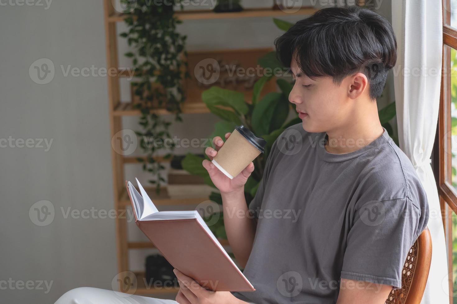 retrato de un hombre blanco sentado dentro de la casa leyendo y tomando café para relajarse en vacaciones. foto