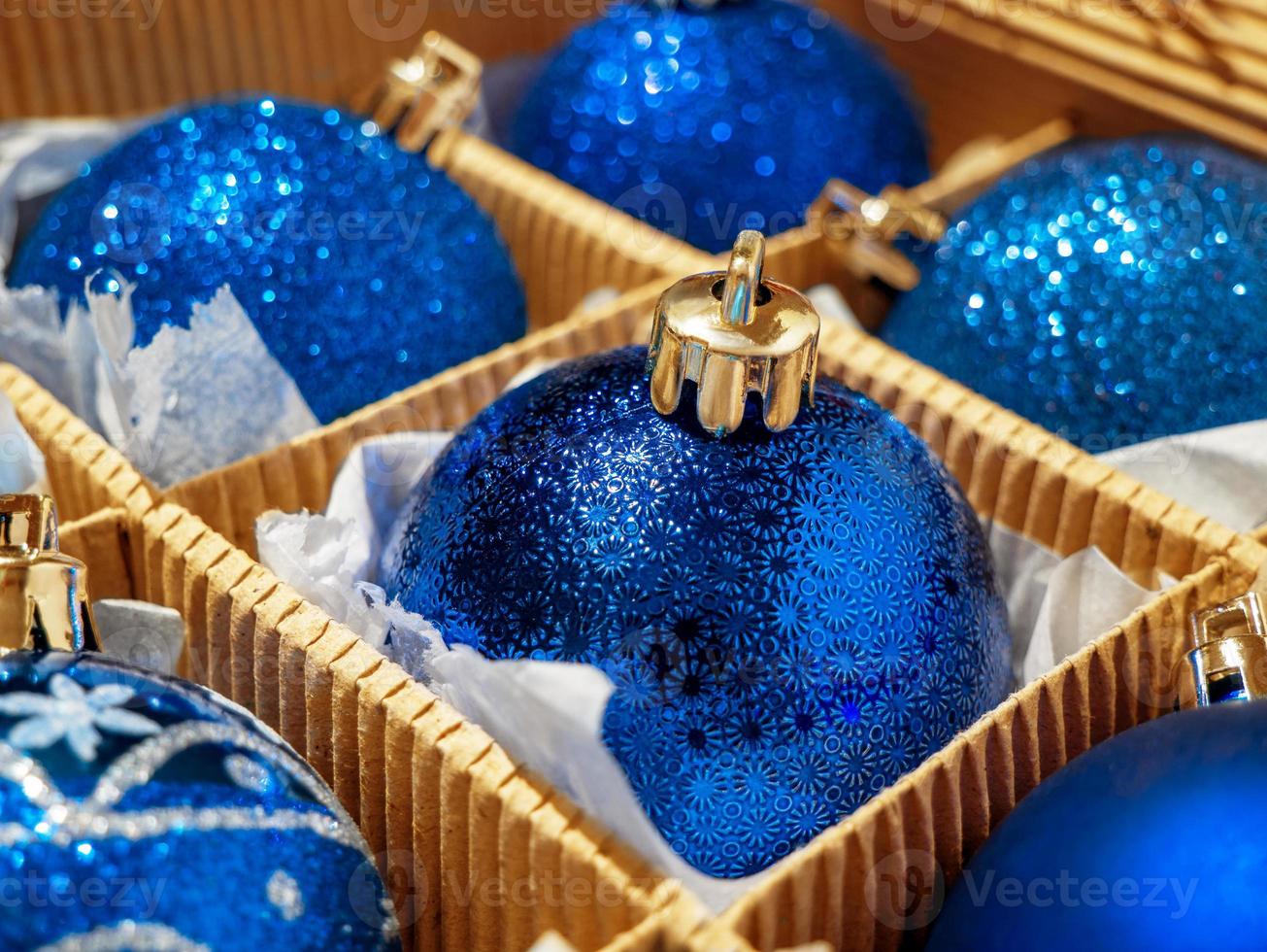 una caja navideña con bolas y regalos navideños azules, baratijas navideñas. preparándose para las vacaciones foto