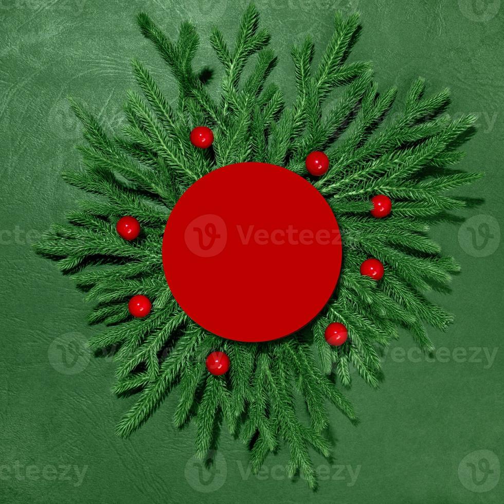 A mock-up of green branches with a red paper card for the inscription. New Year and Christmas. Top view photo