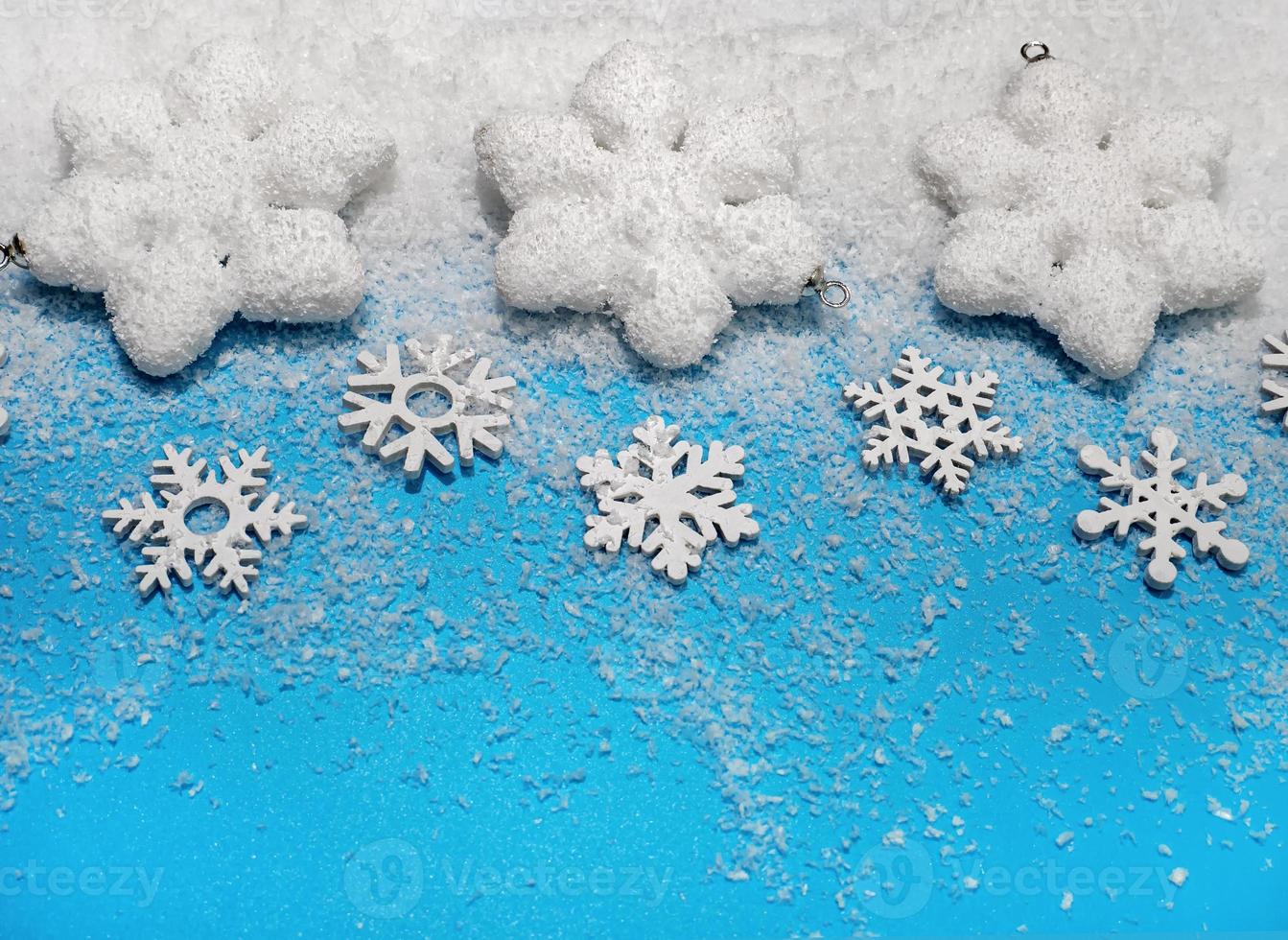 Christmas background. White decorations Christmas balls and snowflakes on soft snow, copy space, place for text photo